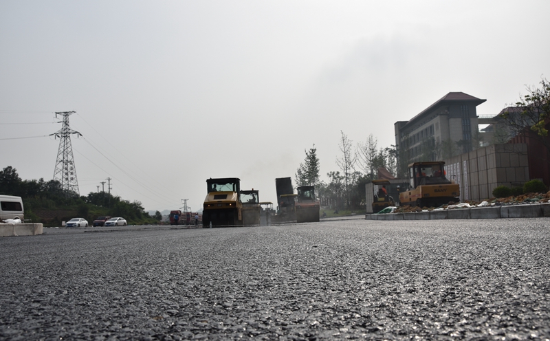 中共泸州市委党校(新校区)北侧主干道沥青混凝土路面施工正加紧进行